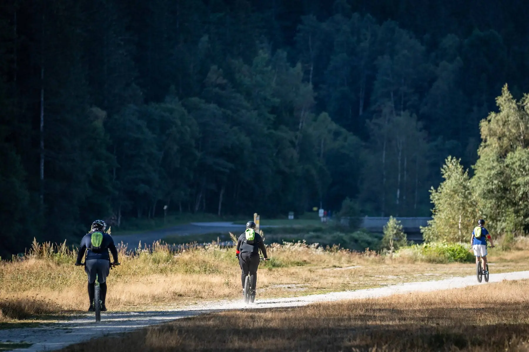 un groupe de personnes circulant à vélo sur un chemin de terre, l'une d'entre elles portant un numéro 10 sur le dos