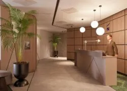 un homme en costume se tient à un bureau de réception devant un mur sur lequel figure la lettre n