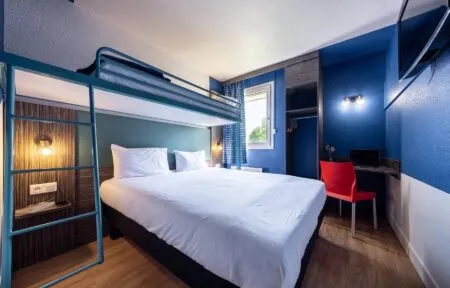 une chambre d'hôtel avec un lit superposé et un bureau