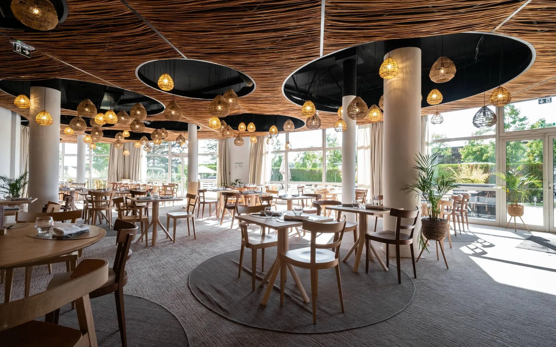 un restaurant avec des tables et des chaises et un plafond en osier