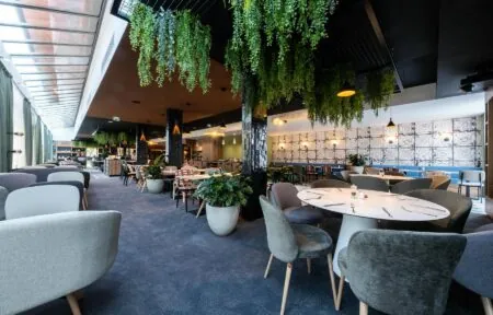 un restaurant avec des tables et des chaises et des plantes suspendues au plafond