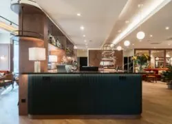 un hall d'hôtel avec un comptoir vert et un bar
