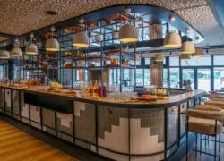 Impressive and stylish central bar, ideal for corporate cocktail service, located at the heart of the restaurant with views of the golf course and the pool