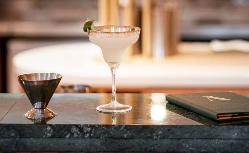 un verre à martini est posé sur un bar à côté d'un menu