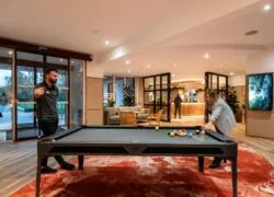 a man and a woman are playing pool in a lobby