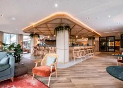 a room with a bar and chairs in it