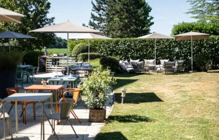 un patio avec tables, chaises et parasols