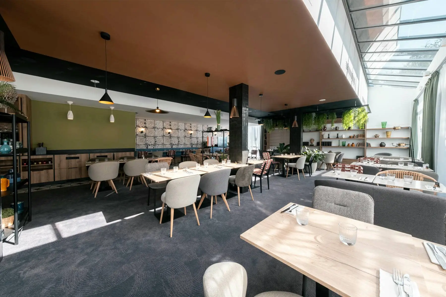 une salle à manger avec des tables et des chaises et un plafond en verre