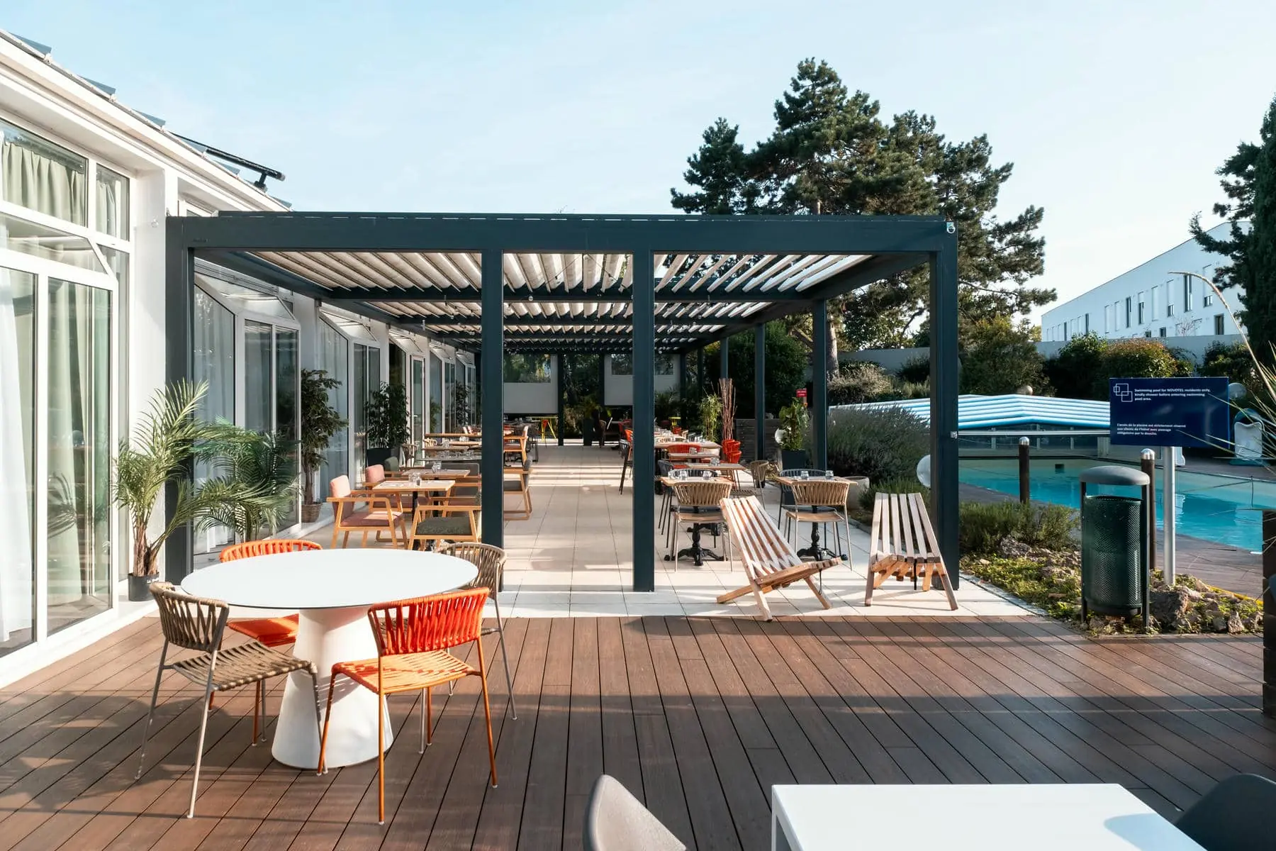 un patio avec tables et chaises sous une pergola