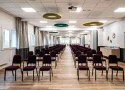 a long room with rows of chairs and a projector