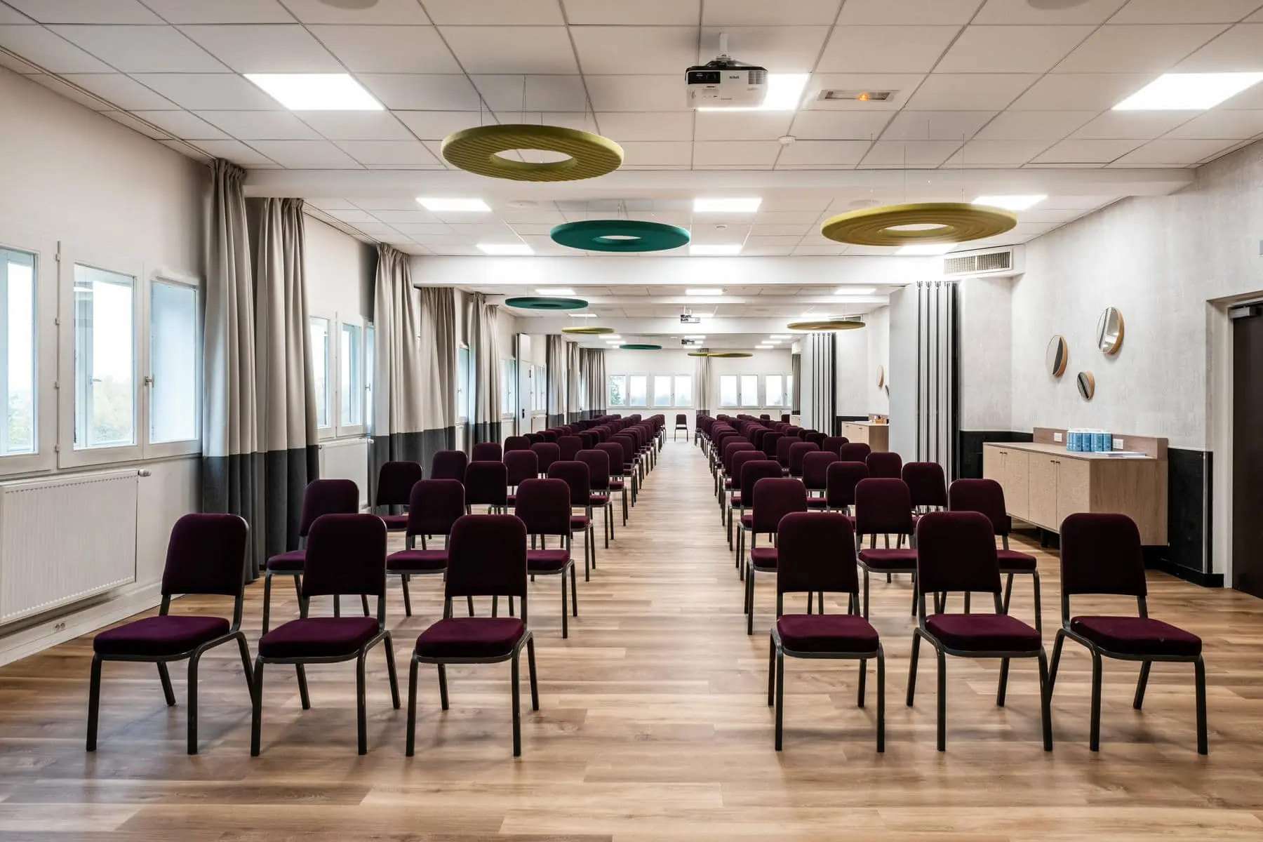 une longue salle avec des rangées de chaises et un projecteur