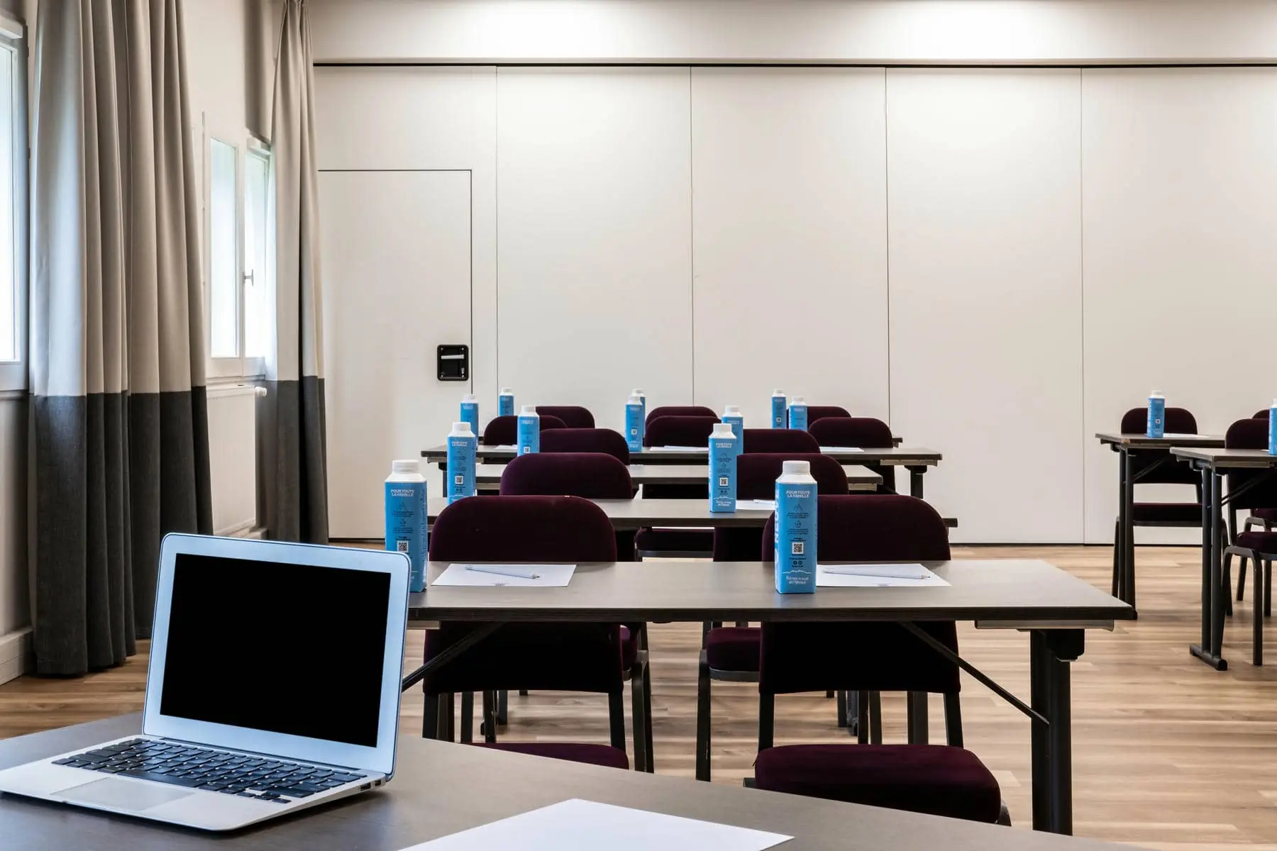 un ordinateur portable est posé sur une table dans une salle de conférence