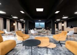 a large room with tables and chairs and a projector screen