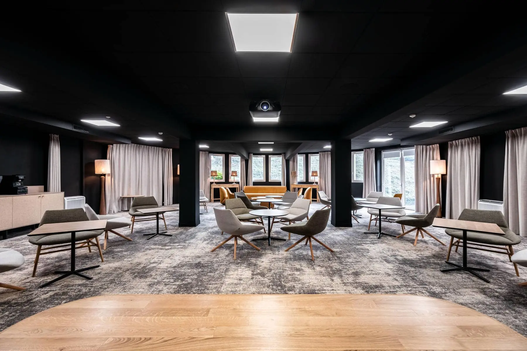 une salle avec des tables et des chaises et un projecteur au plafond