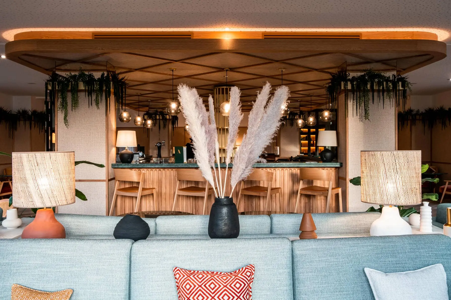 un salon avec un canapé et un vase d'herbe de la pampa