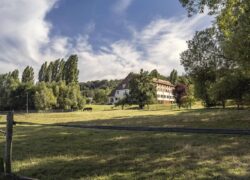 a fenced in field with a house in the background