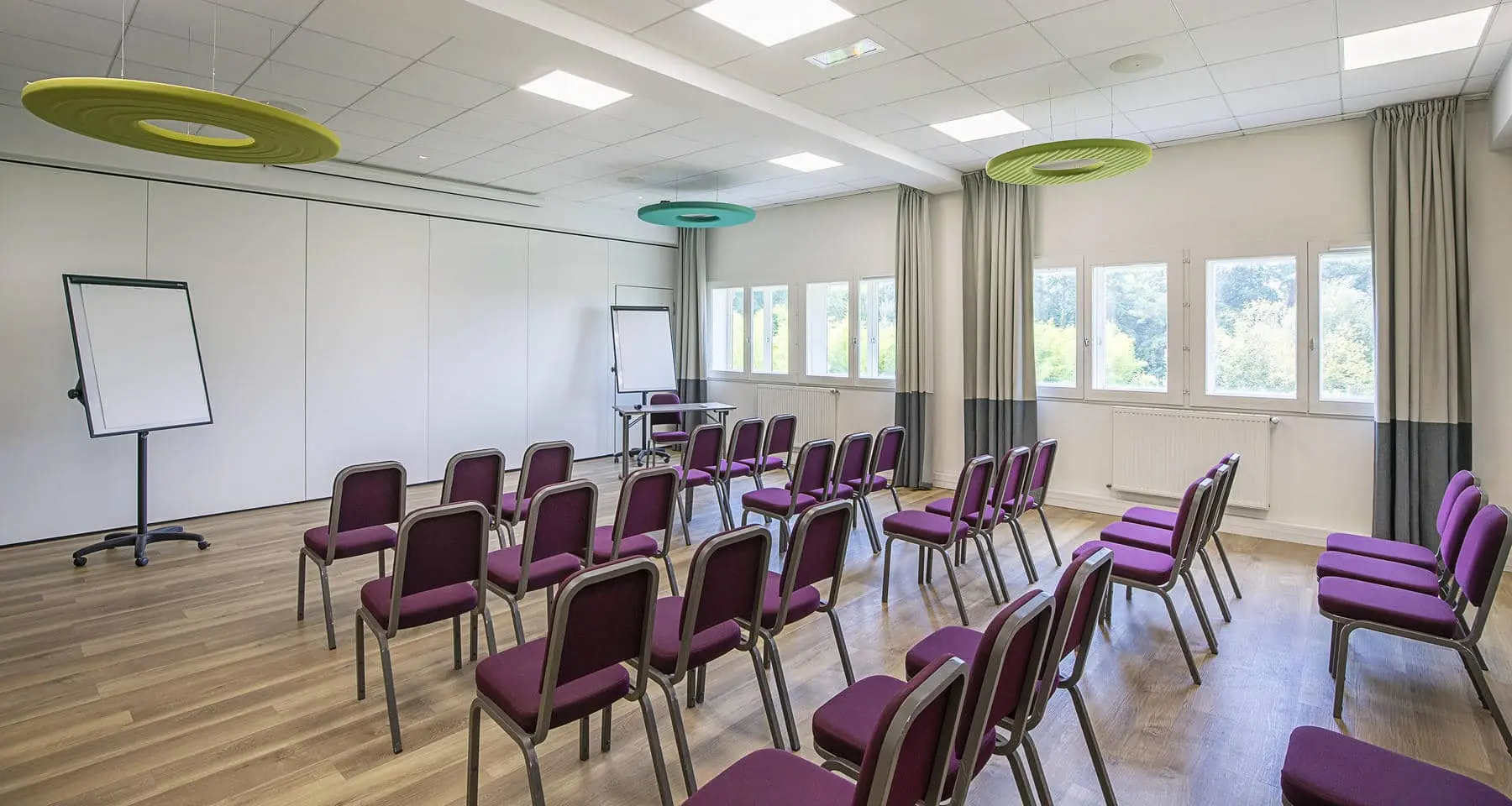 une salle de conférence avec des chaises violettes et un tableau blanc