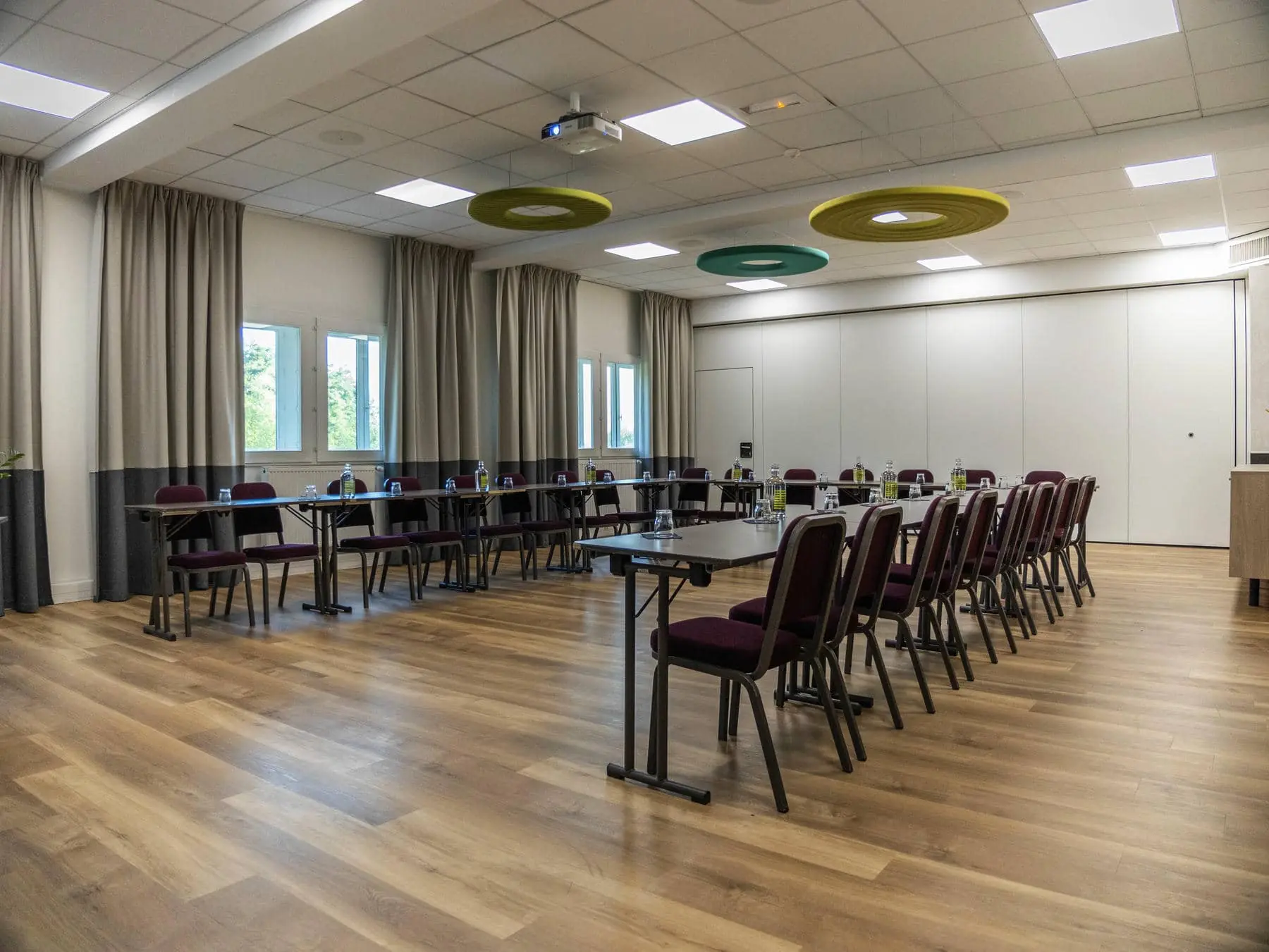 une salle de conférence avec tables et chaises et un projecteur