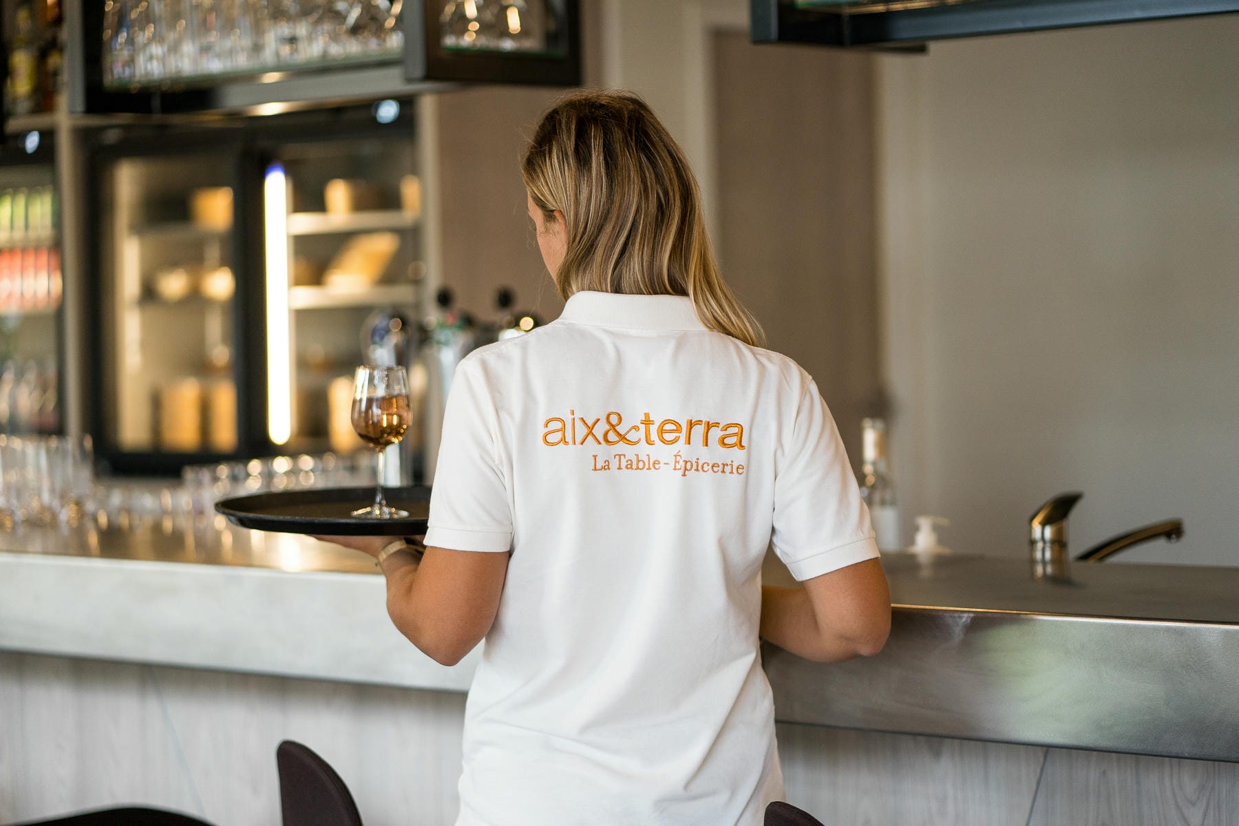 une femme portant une chemise blanche avec l'inscription aix & terra