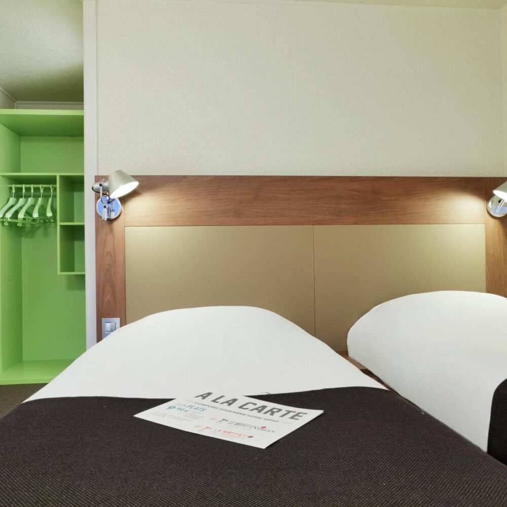a hotel room with two beds and a sign that says a la carte