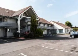 un parking devant un bâtiment avec un panneau indiquant " hôtel "