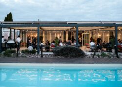 un groupe de personnes est rassemblé sous une pergola près d'une piscine