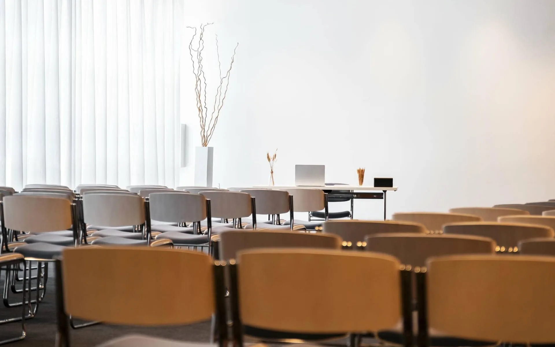 rows of chairs in a room with a laptop on a table