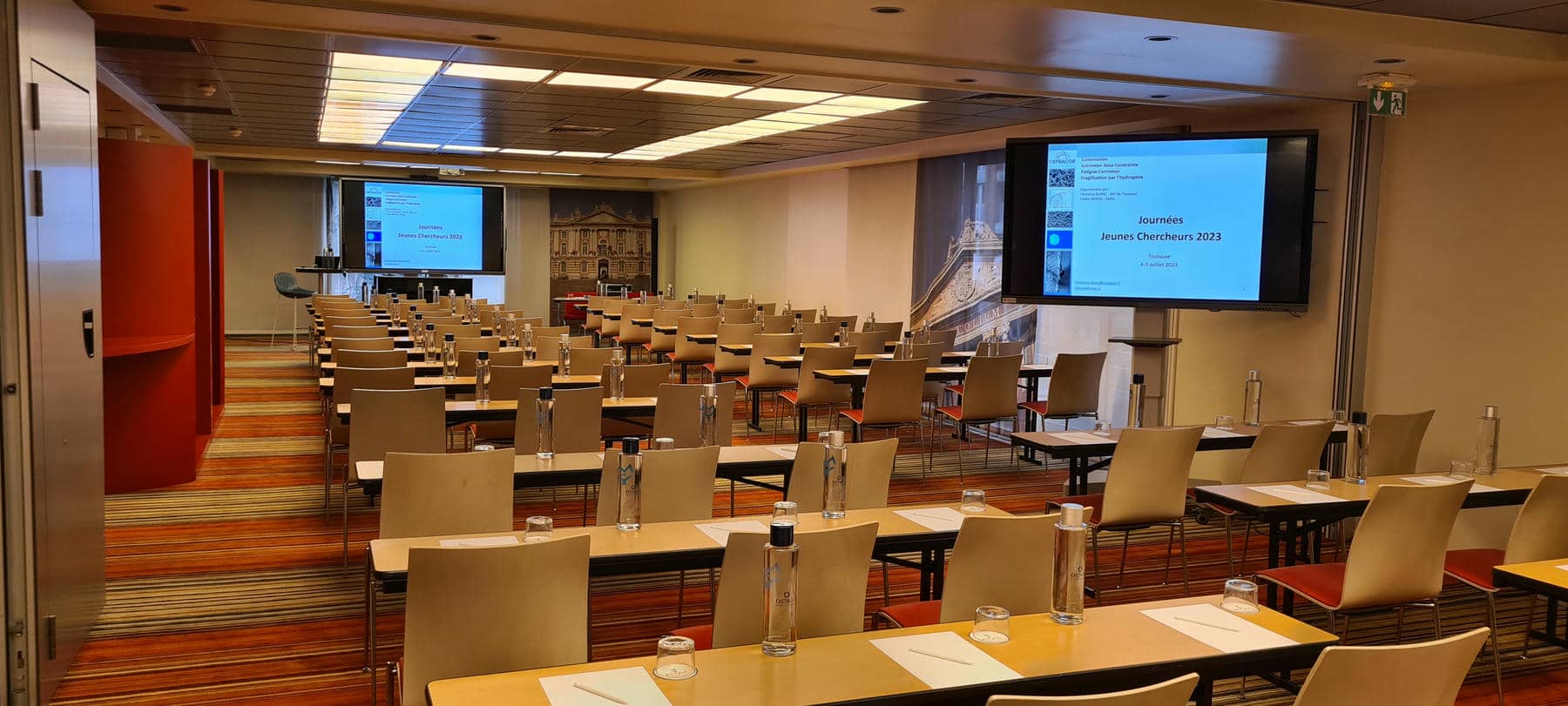 a large room with tables and chairs and a large screen that says james denton 2013