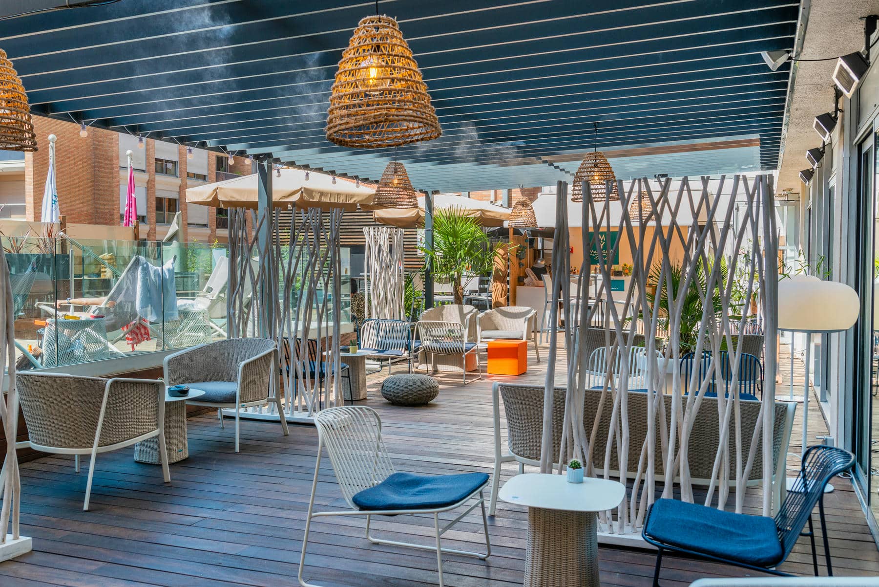 a patio with wicker chairs and tables under a canopy