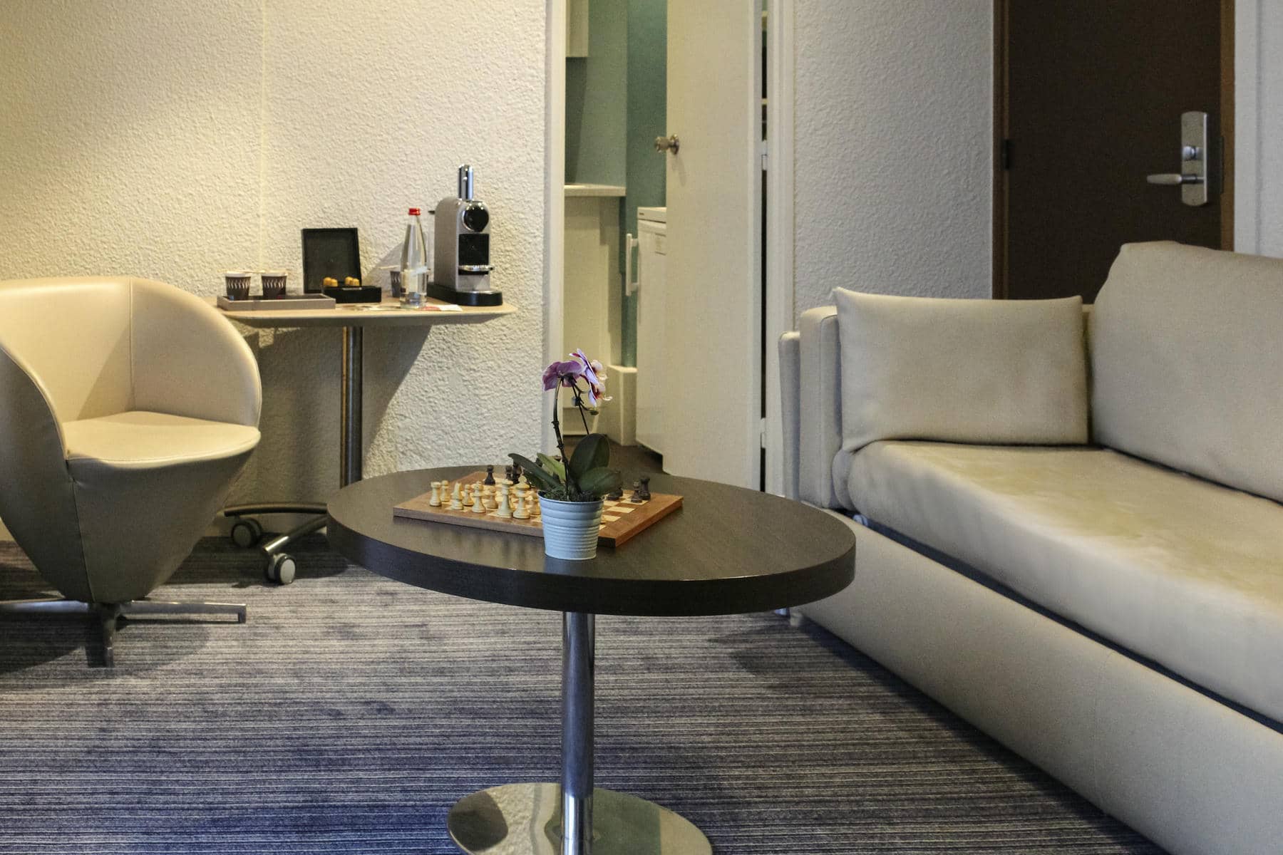 a chess board sits on a small table in a hotel room