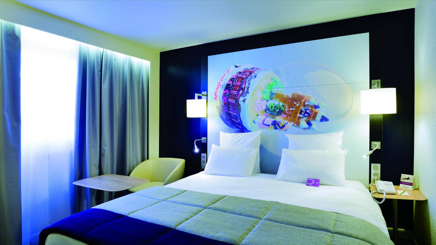 a hotel room with a purple pillow on the bed