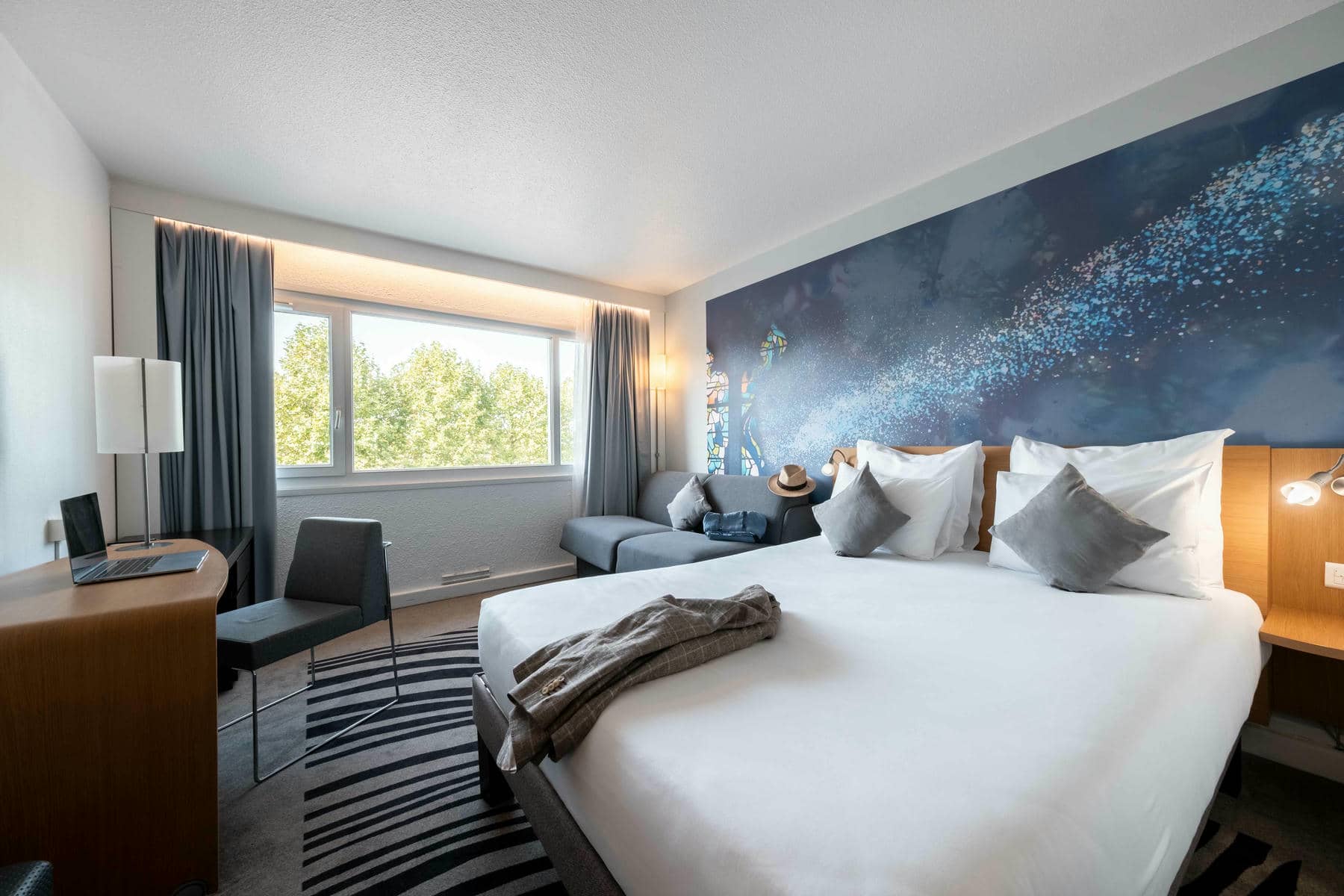 une chambre d'hôtel avec un grand lit et une grande fenêtre