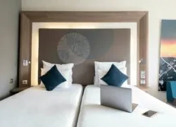 a hotel room with two beds and a laptop on the bed