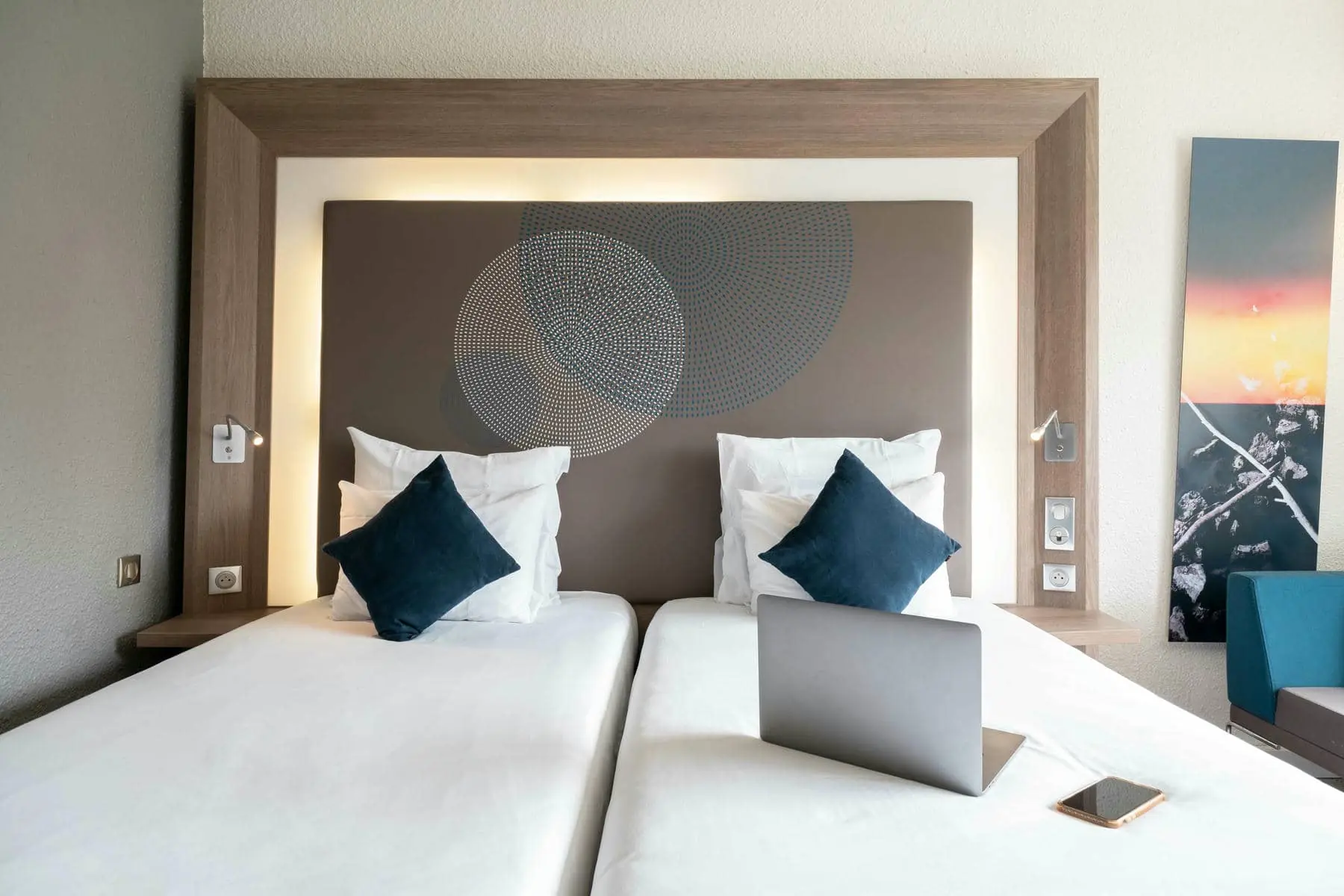 une chambre d'hôtel avec deux lits et un ordinateur portable sur le lit