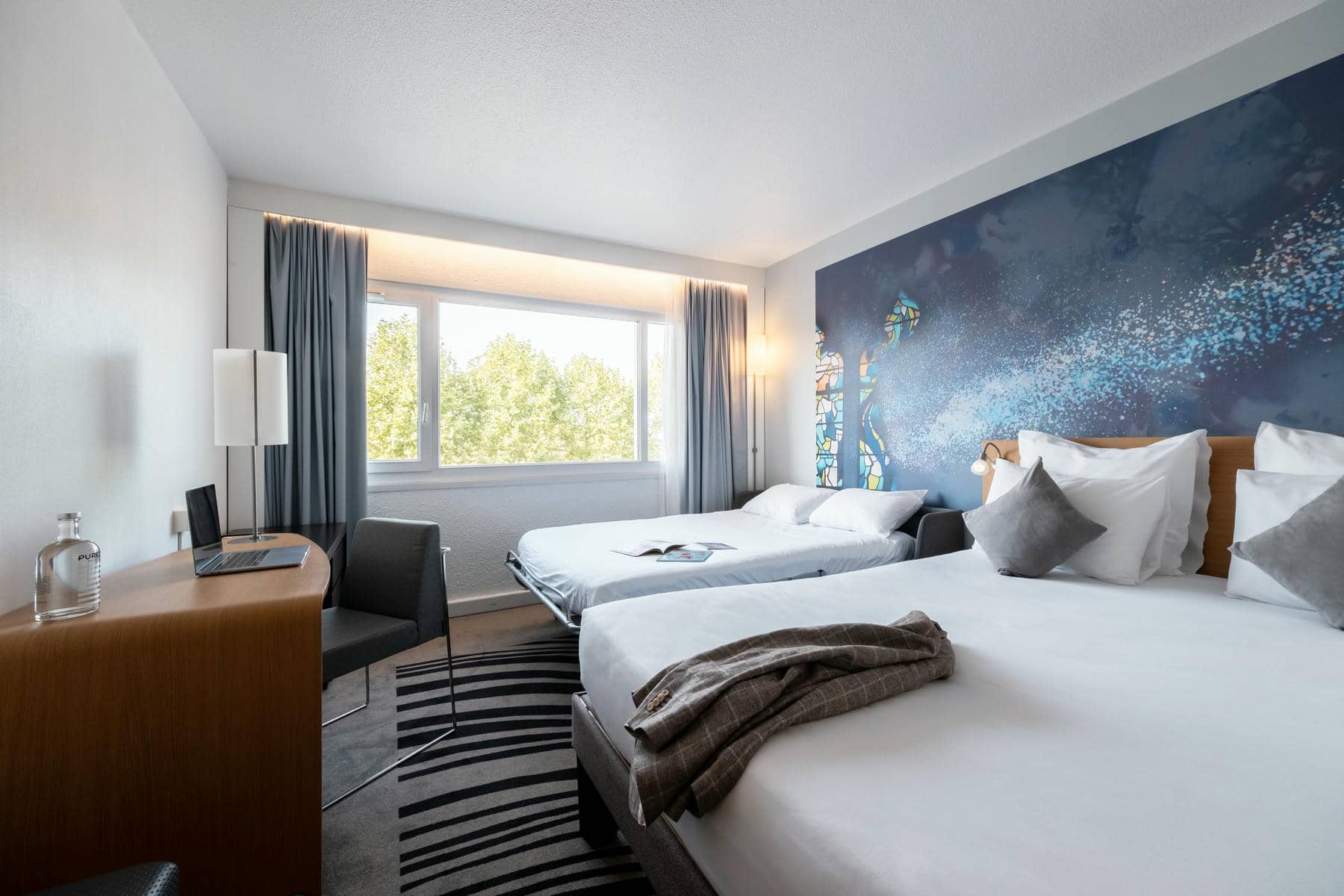 une chambre d'hôtel avec deux lits et un bureau