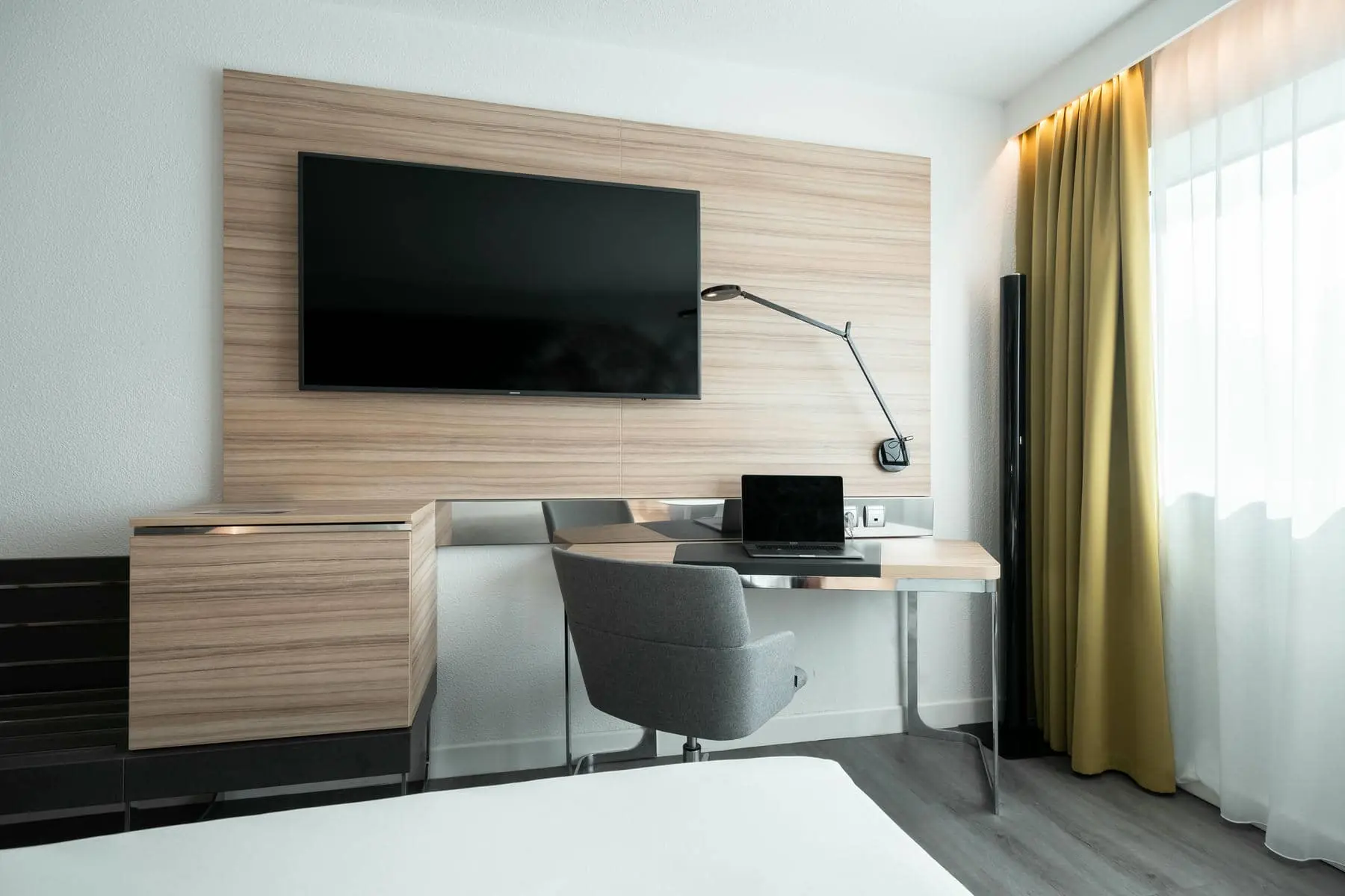une chambre d'hôtel avec un bureau et une télévision à écran plat