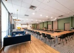 a large room with tables and chairs and a blue couch