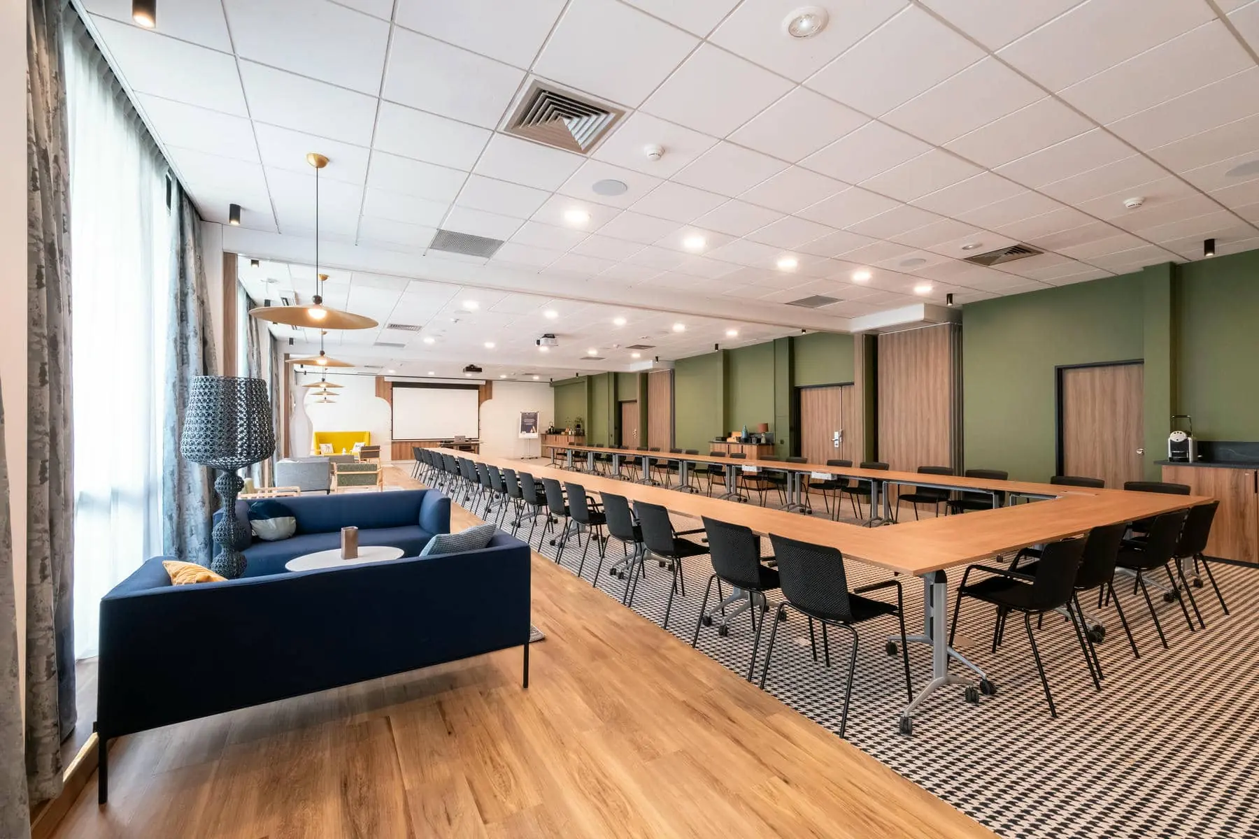 une grande salle avec des tables et des chaises et un canapé bleu