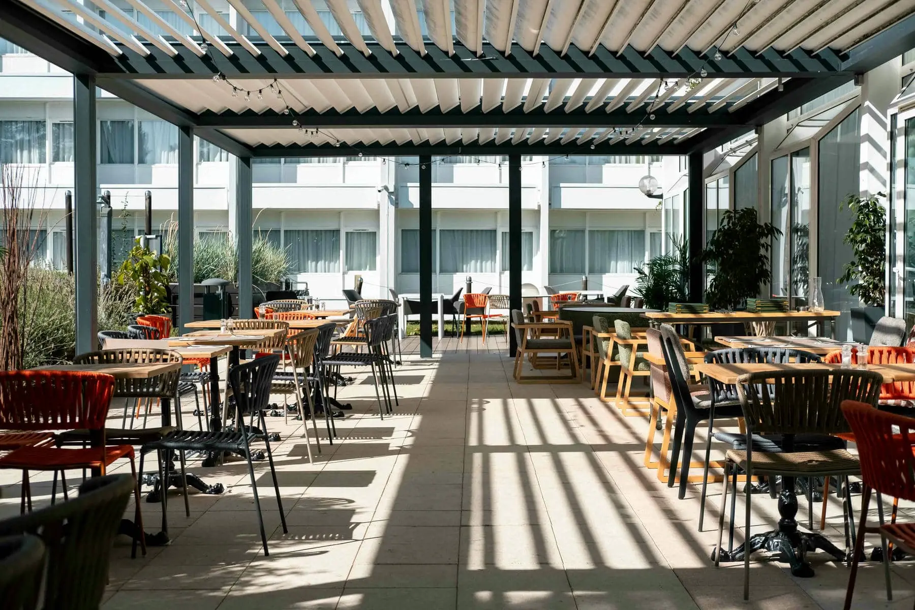 un restaurant avec tables et chaises sous une pergola