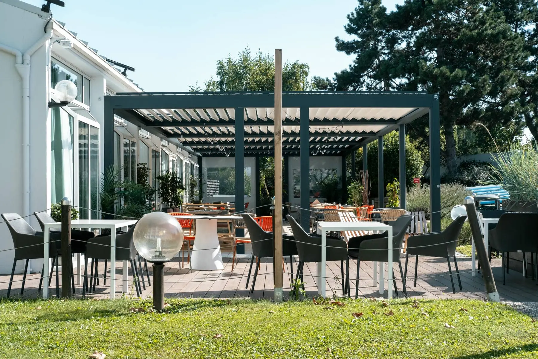 un patio avec tables et chaises sous une pergola