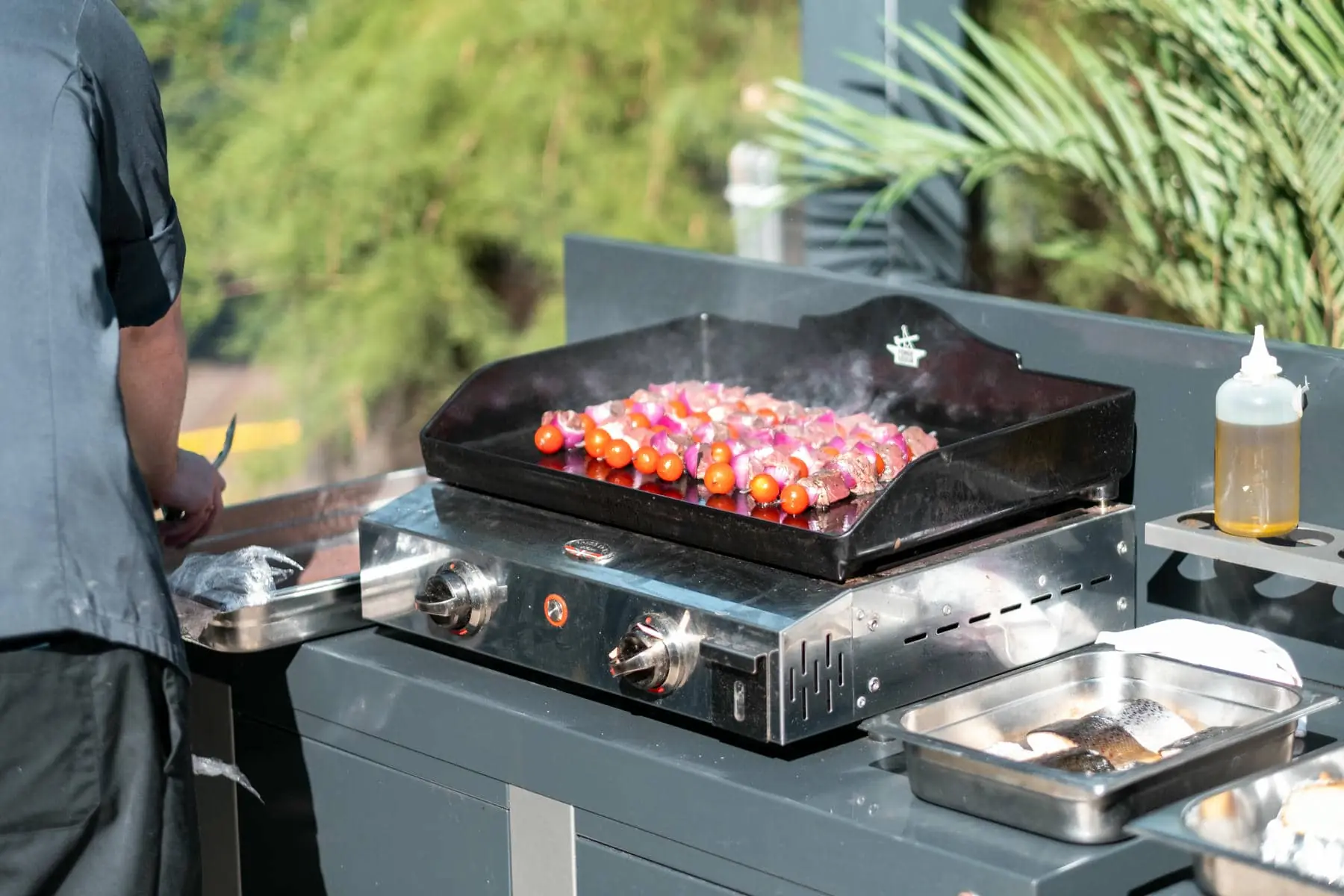 une bouteille de sauce est posée sur un comptoir à côté d'un grill