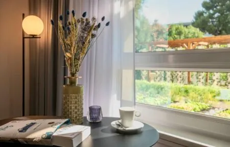 un livre sur une table à côté d'un vase avec des fleurs et une tasse de café