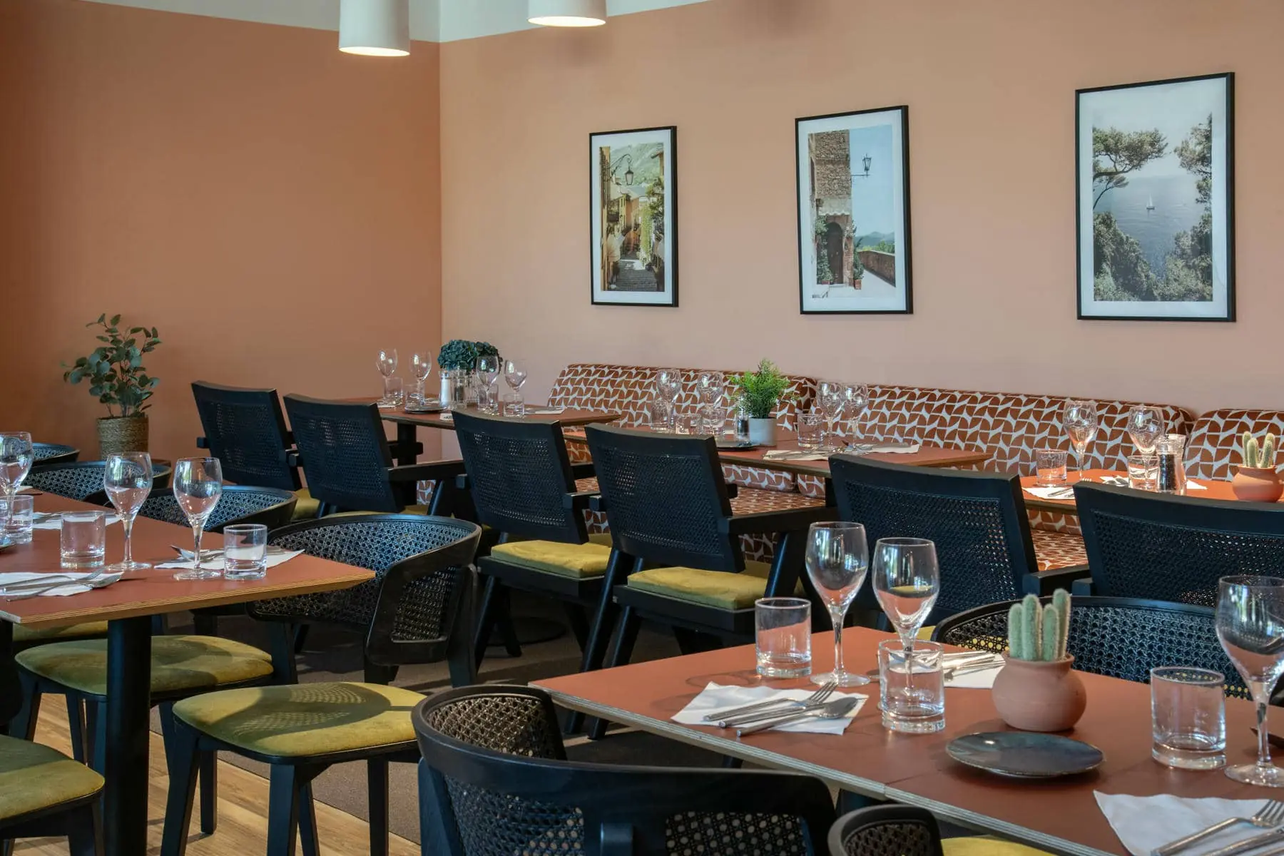 une salle à manger avec des tables et des chaises et des tableaux au mur