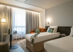 a hotel room with two beds and a chair