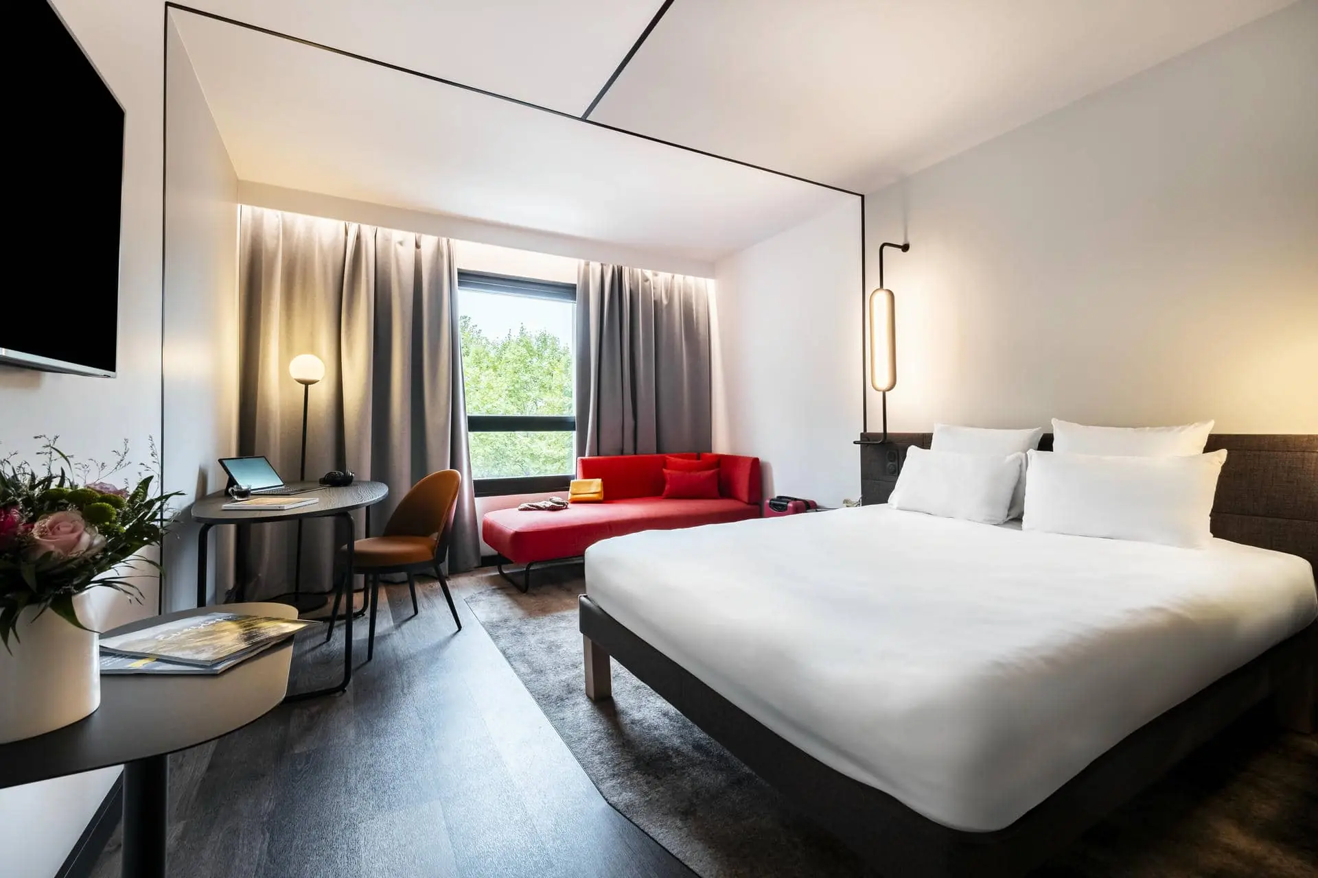 une chambre d'hôtel avec un grand lit et un canapé rouge