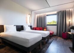 a hotel room with two beds and a red couch