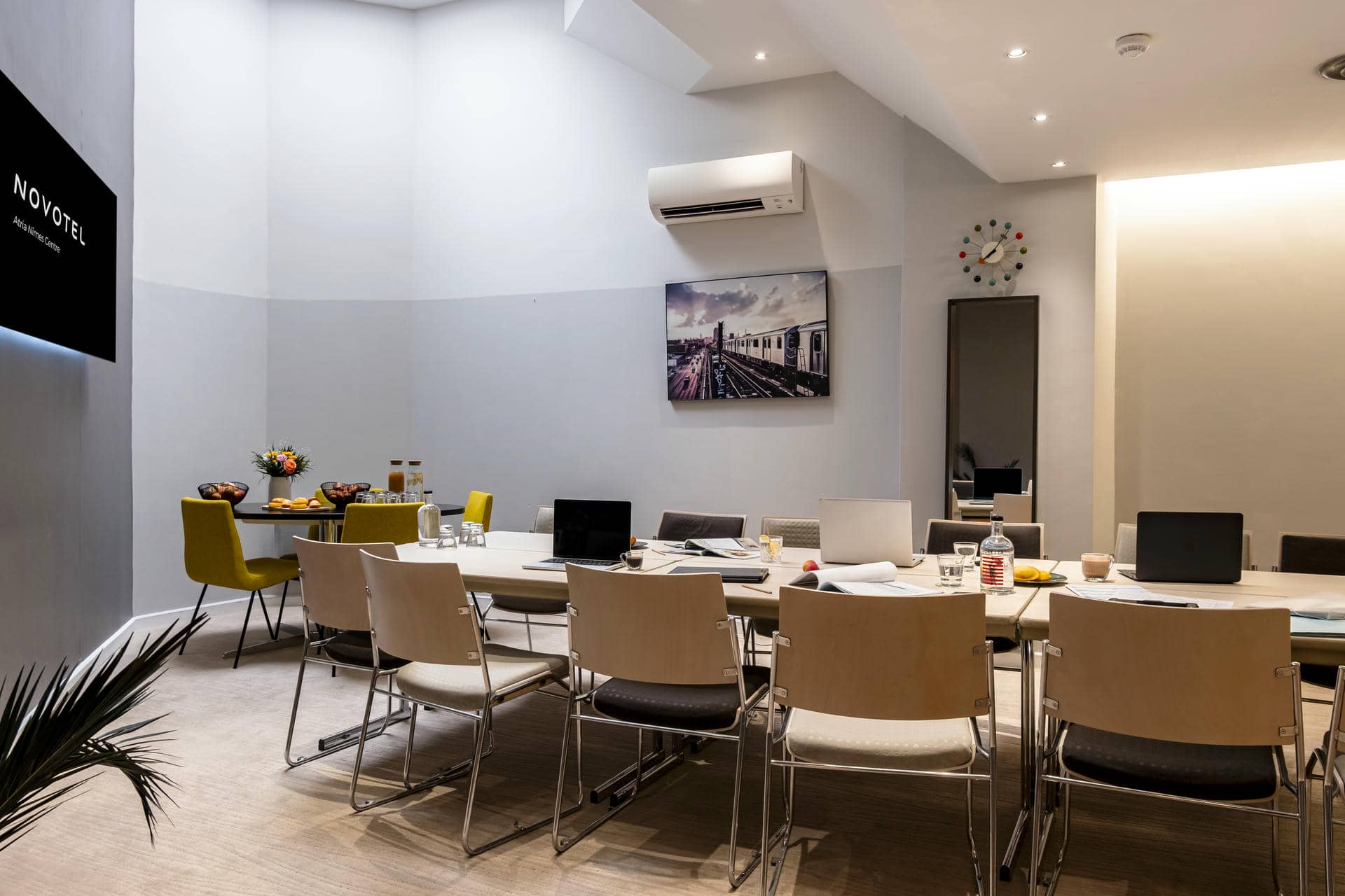 une salle de conférence avec un grand écran sur lequel est inscrit novotel