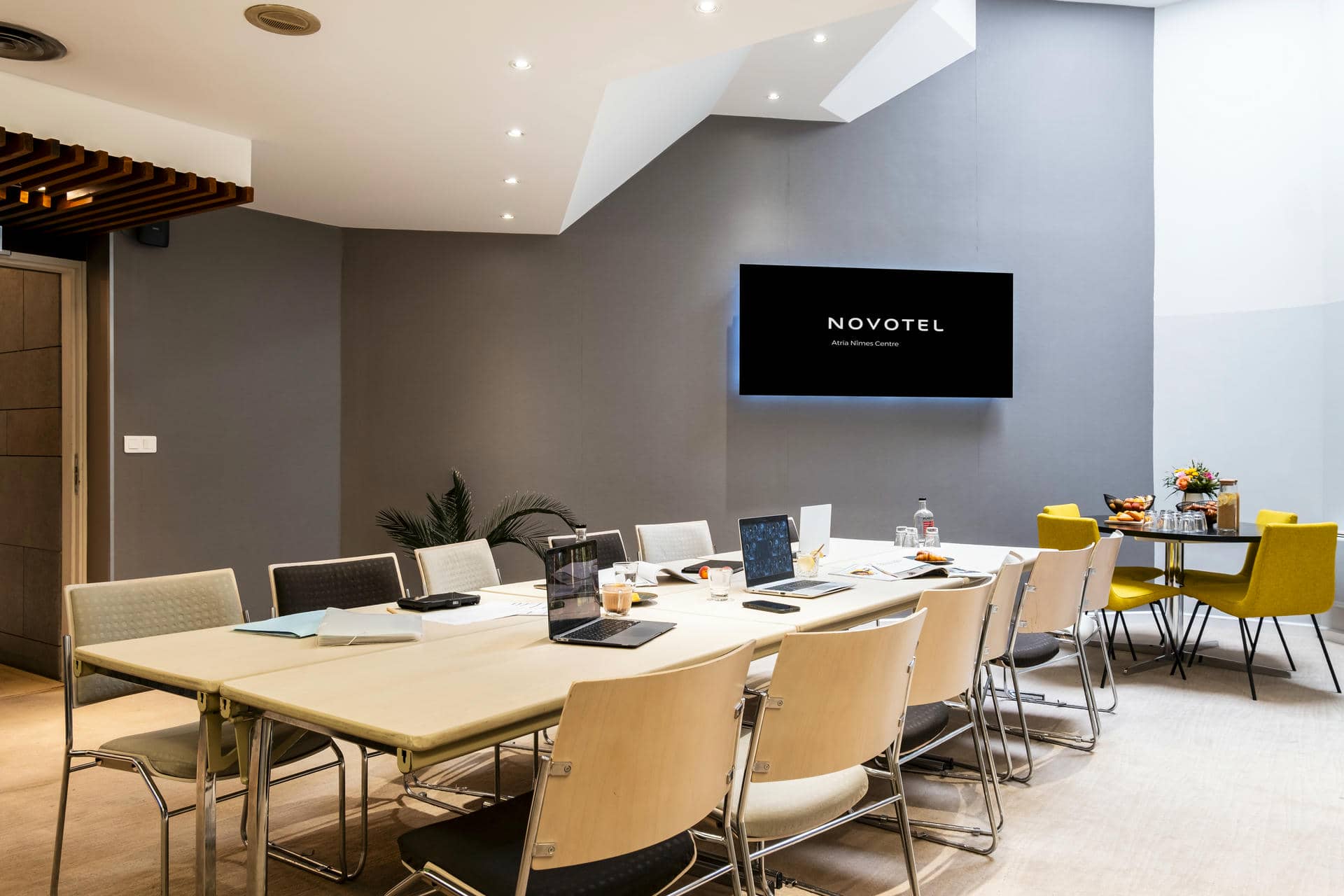 une salle de conférence avec un panneau novotel sur le mur