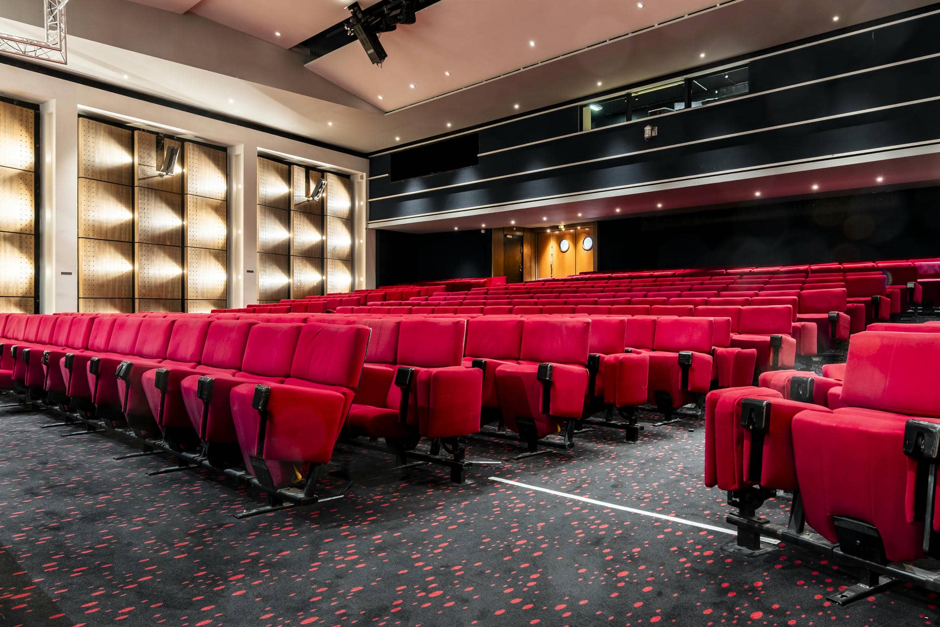 des rangées de sièges rouges dans un grand auditorium