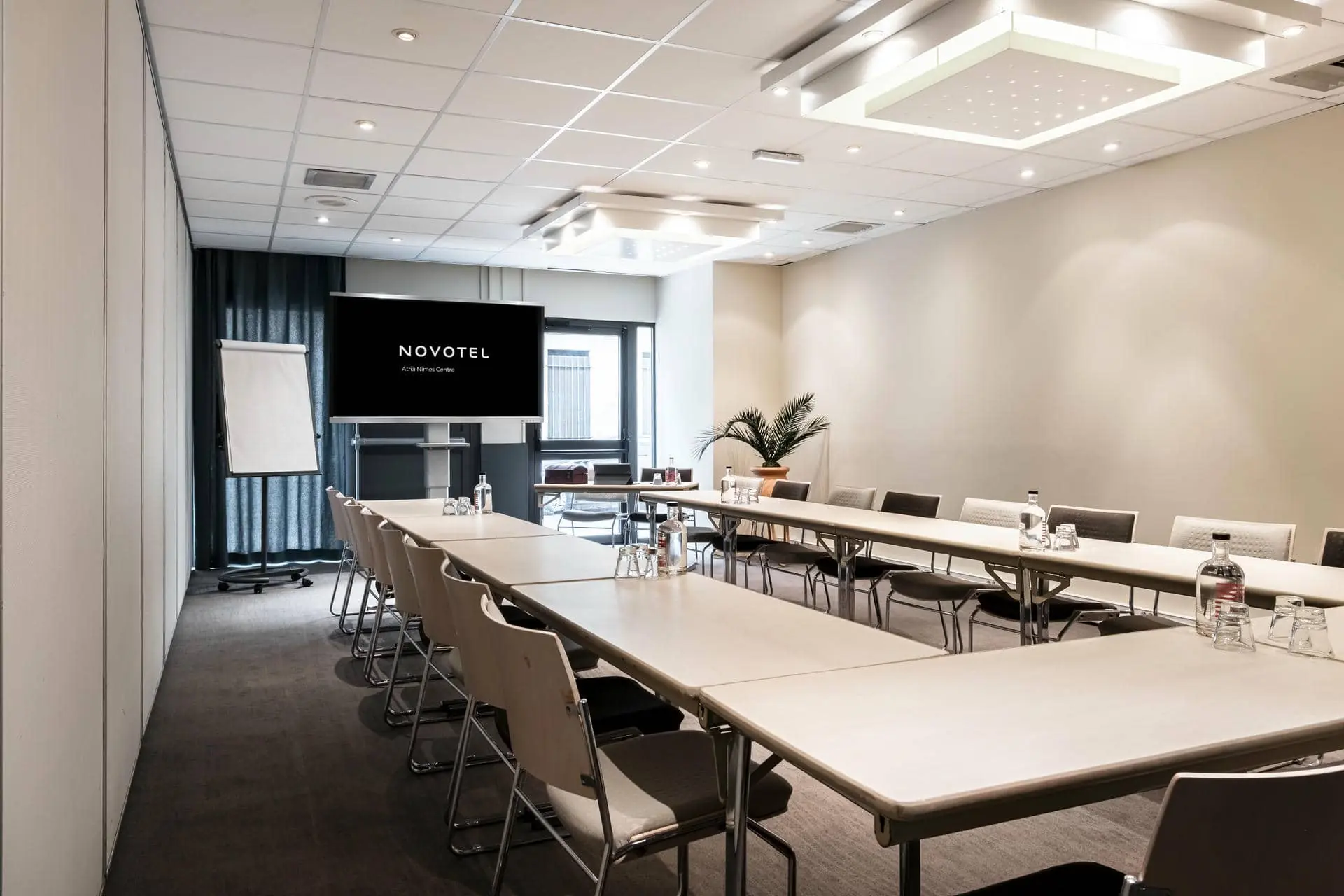 une salle de conférence novotel avec tables et chaises